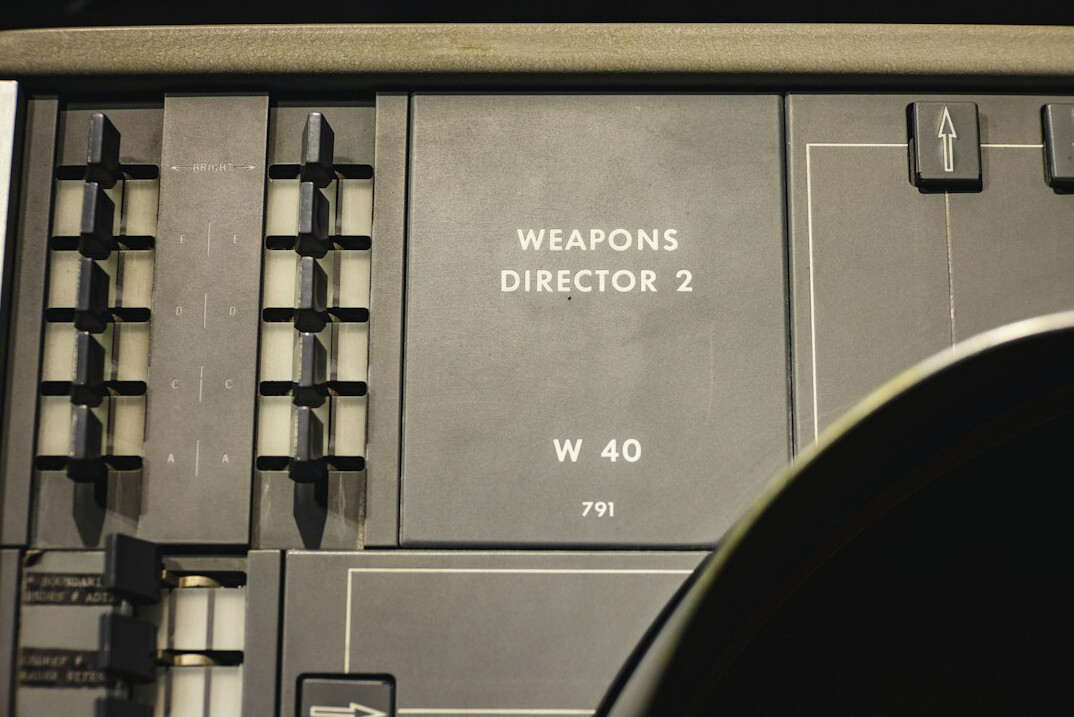 Close-up of a broadcast vision mixer with illuminated buttons and faders
